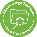 Green circular icon with magnifying glass over an open file folder symbol. The text 'Kāwanatanga Tuwhera' is above the symbol and 'Open Government' below.