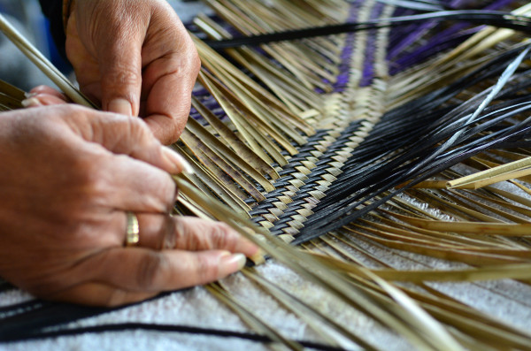 Hands weaving flax