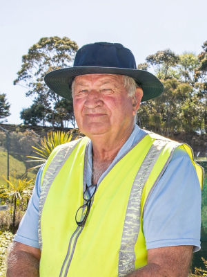 Bill Bean wearing a high vis vest standing in the vege garden at Auckland Prison