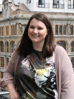 Cat Simpson standing in front of CBD buildings and smiling at the camera