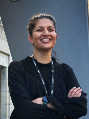Chetna Pancha standing in front of the MBIE office looking at the camera and smiling