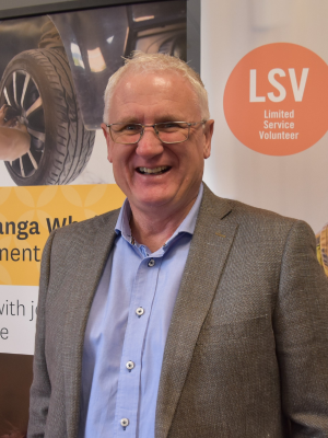 Craig Churchill standing in front of a career banner looking at the camera and smiling