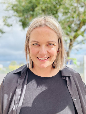 Jess standing outside facing the camera and smiling