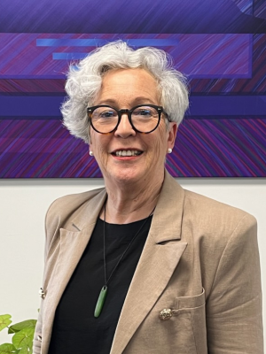 Karen Bartlett wearing a brown blazer looking at the camera and smiling