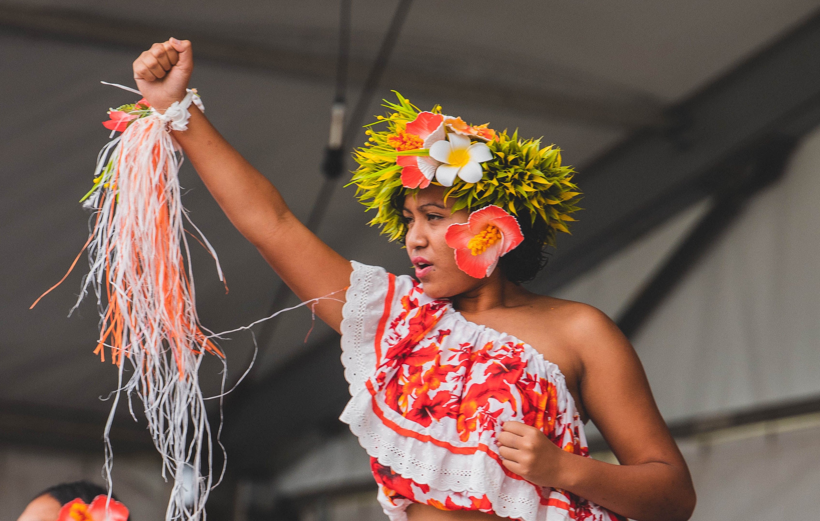 A young woman dancing in traditional dress and headwear.