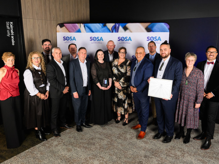 The DLIP team standing in front of the SOSA banner smiling at the camera