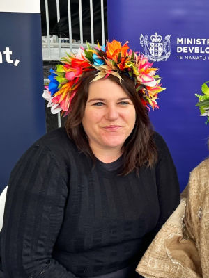 Steph Voight wearing a flower garland on her head looking at the camera and smiling