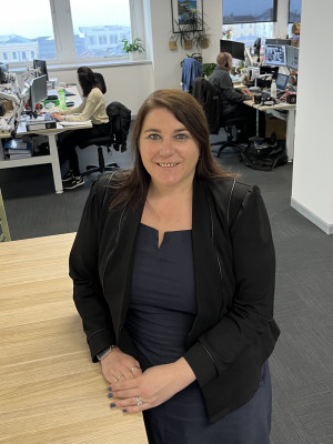 Steph Voight standing in an office looking at the camera and smiling