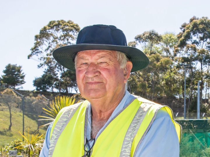 Bill Bean wearing a high vis vest standing in the vege garden at Auckland Prison