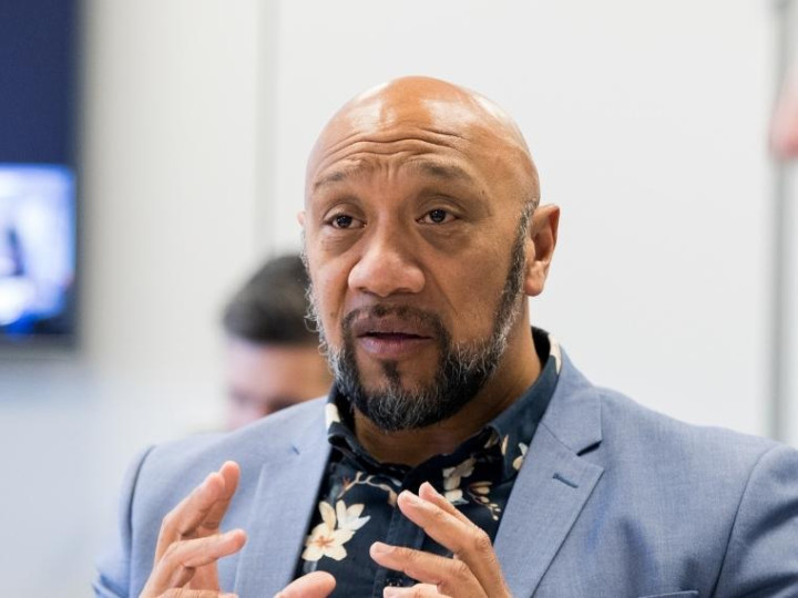 Ezra Schuster talking with a group of people in a meeting room