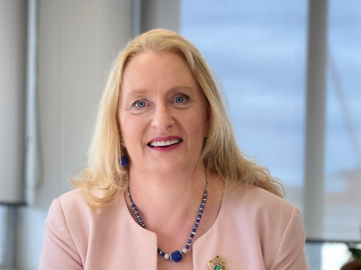 Grainne Moss sitting at a desk looking at the camera and smiling