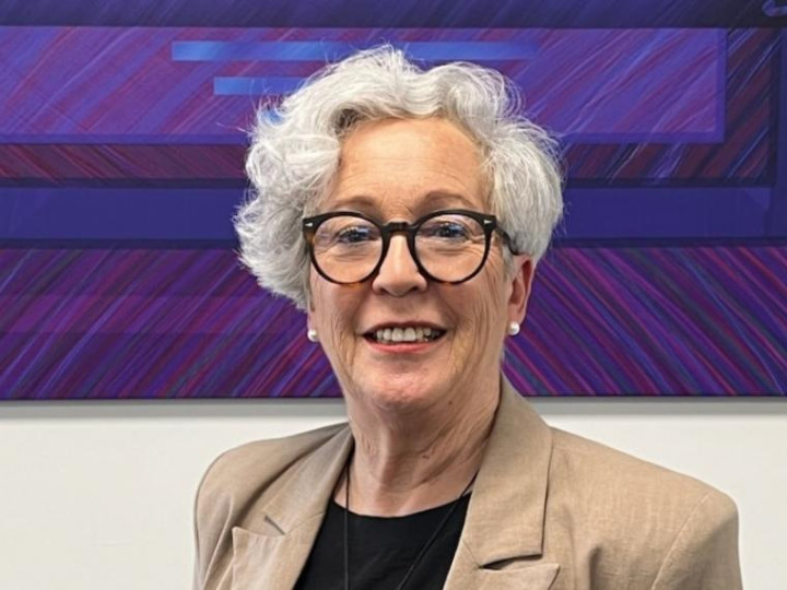 Karen Bartlett wearing a brown blazer looking at the camera and smiling