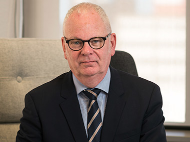 Peter Hughes sitting in an office chair looking directly at the camera